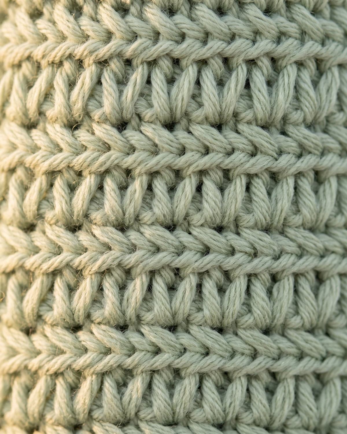 Close-up of rows of tall crochet stitches in pale sage green yarn