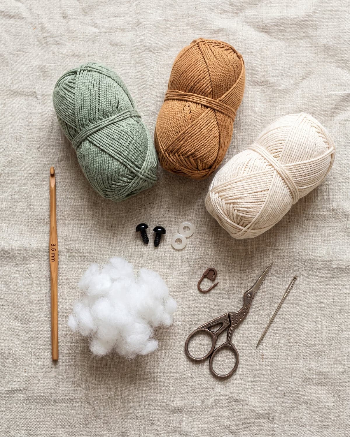 Sage, caramel and cream cotton yarn with a crochet hook, safety eyes, stuffing, a stitch marker, scissors and a needle